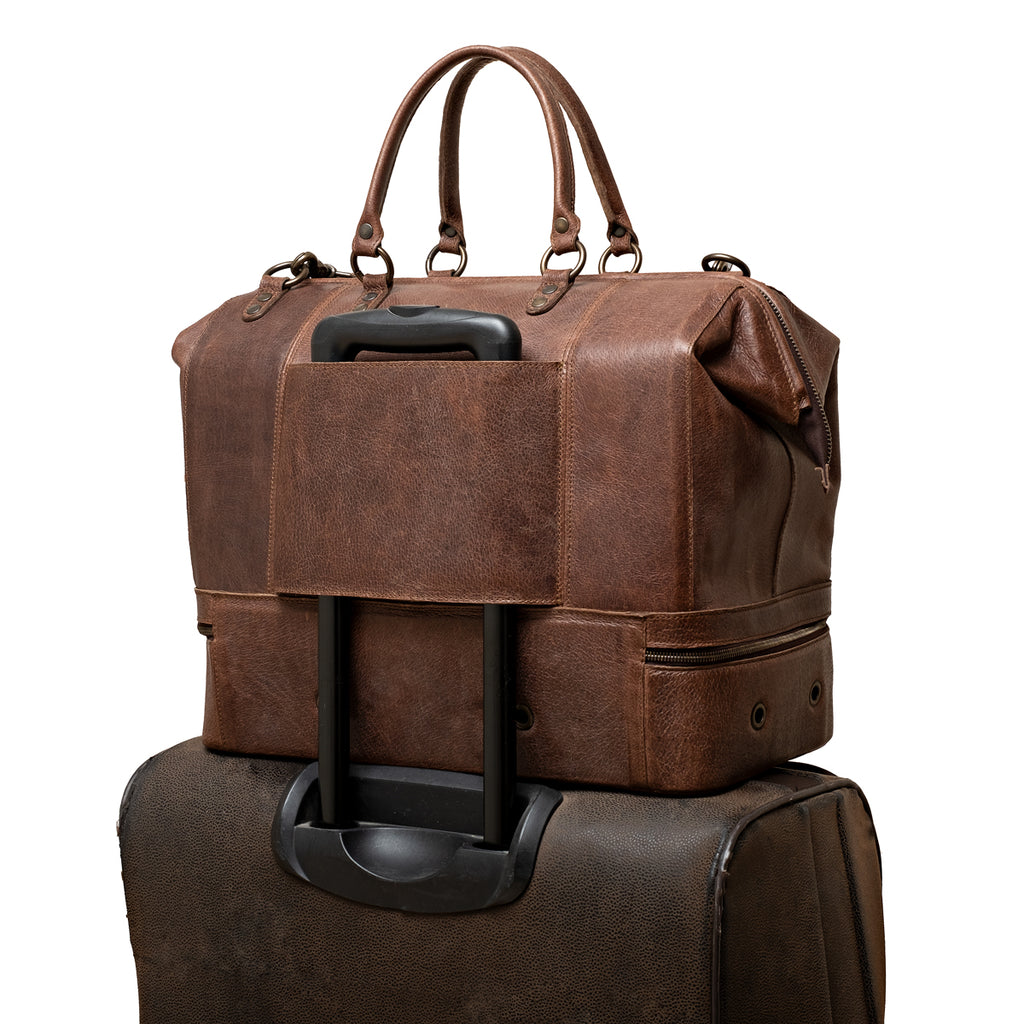 Two Compartment Duffle in Dark Coffee Brown, back trolley sleeve slid over a rolling suitcase handle
