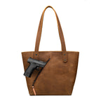 Concealed Carry Leather Tote in Tobacco, front view with a pistol emerging from the diagonal concealed carry pocket