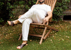 A man relaxing in a wooden lounge chair on the lawn wearing Jesus Sandals in Dark Coffee Brown