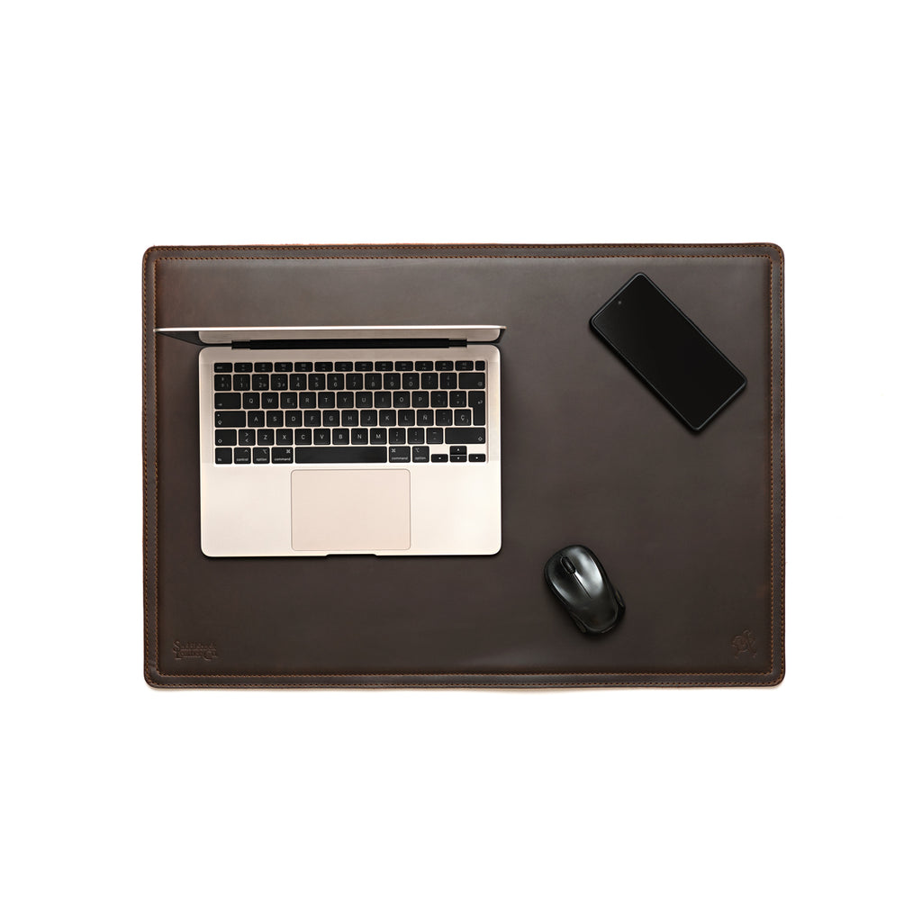 Desk Pad in Dark Coffee Brown styled as a workspace with a laptop, phone and mouse, overhead view