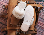 Women's Sheepskin Slippers in Tobacco, slipper and upturned sole resting on a leather bag