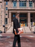 Silverback Document Holder in English Tan, carried by a man in a black suit in front of a historic building