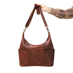 Women's Hobo Organizer Bag in Chestnut, held up by its shoulder strap showing the front pockets