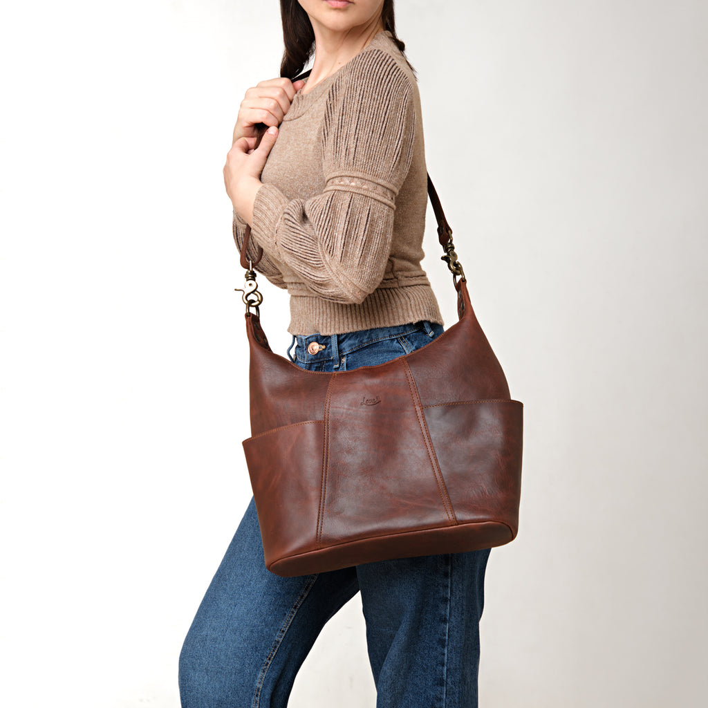 Women's Hobo Organizer Bag in Chestnut, carried on the shoulder by a woman in a knit sweater and jeans