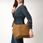Women's Hobo Organizer Bag in Tobacco, carried on the shoulder by a woman in a dark blue blouse