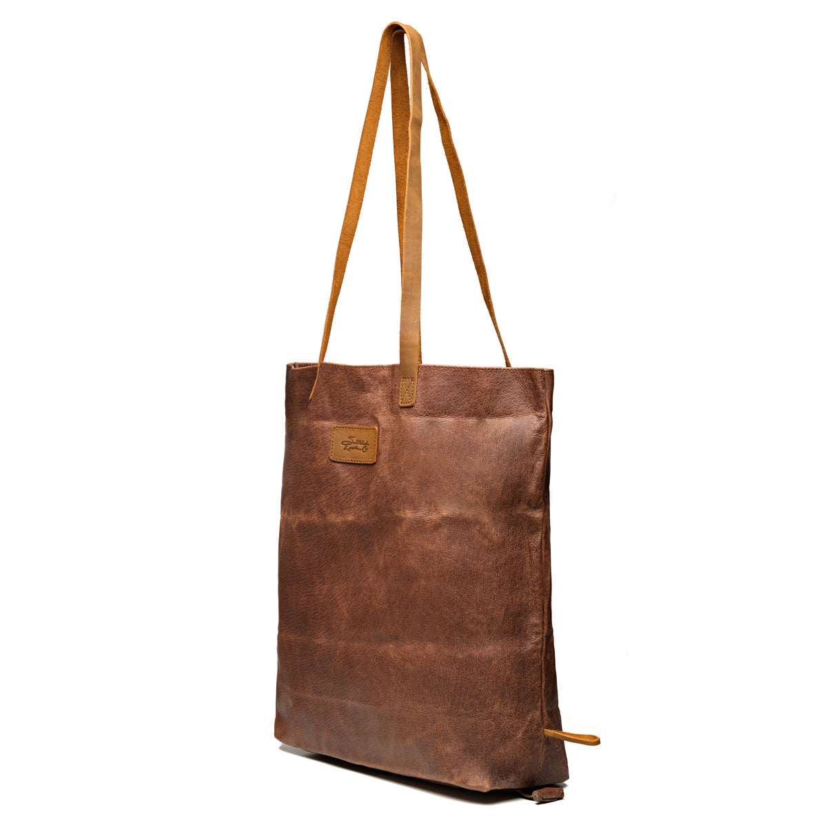 Travel Tote in Burnt Sausage, angled front view with leather logo patch and tall shoulder handles