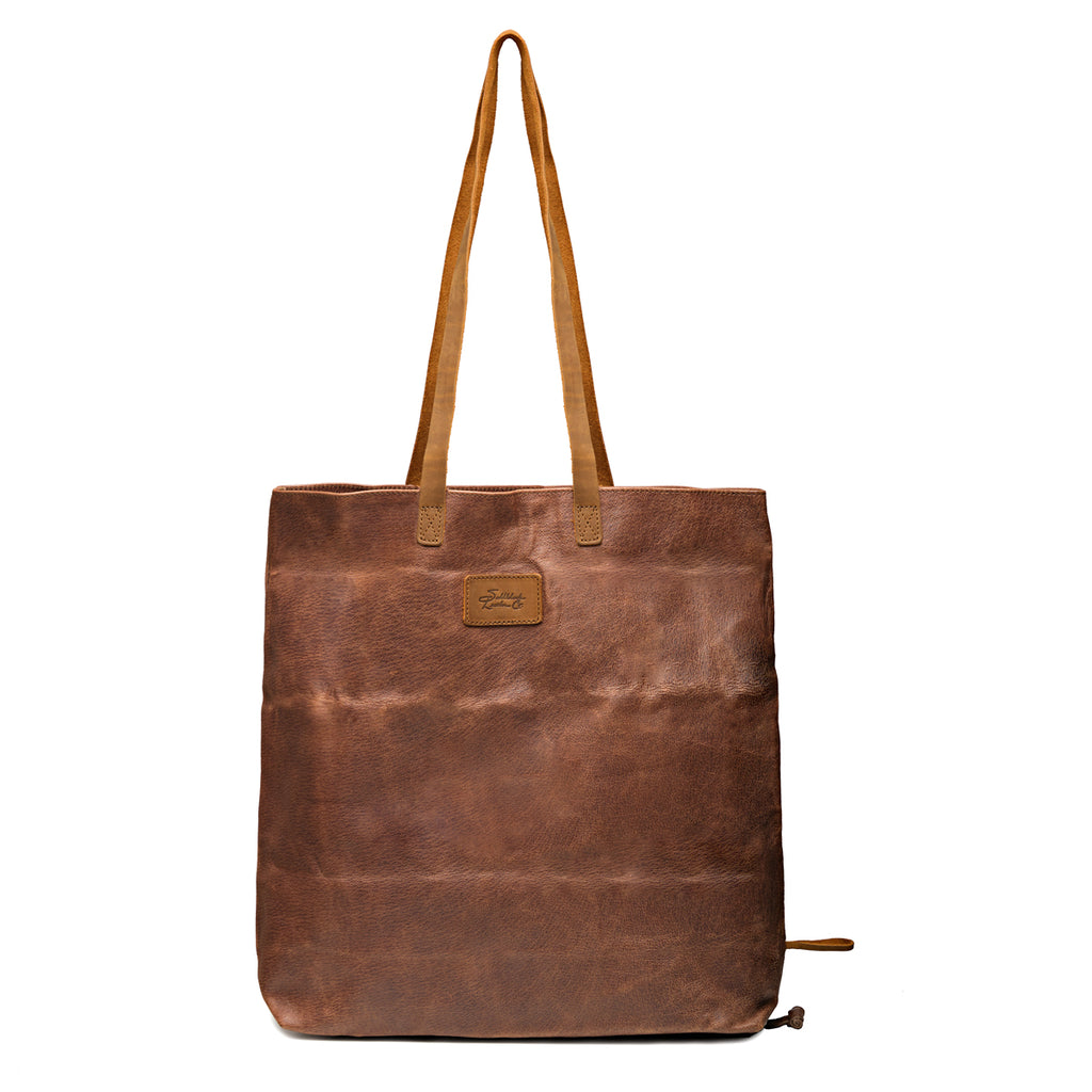 Travel Tote in Burnt Sausage, front view with leather logo patch, ridged hogsback leather and shoulder handles