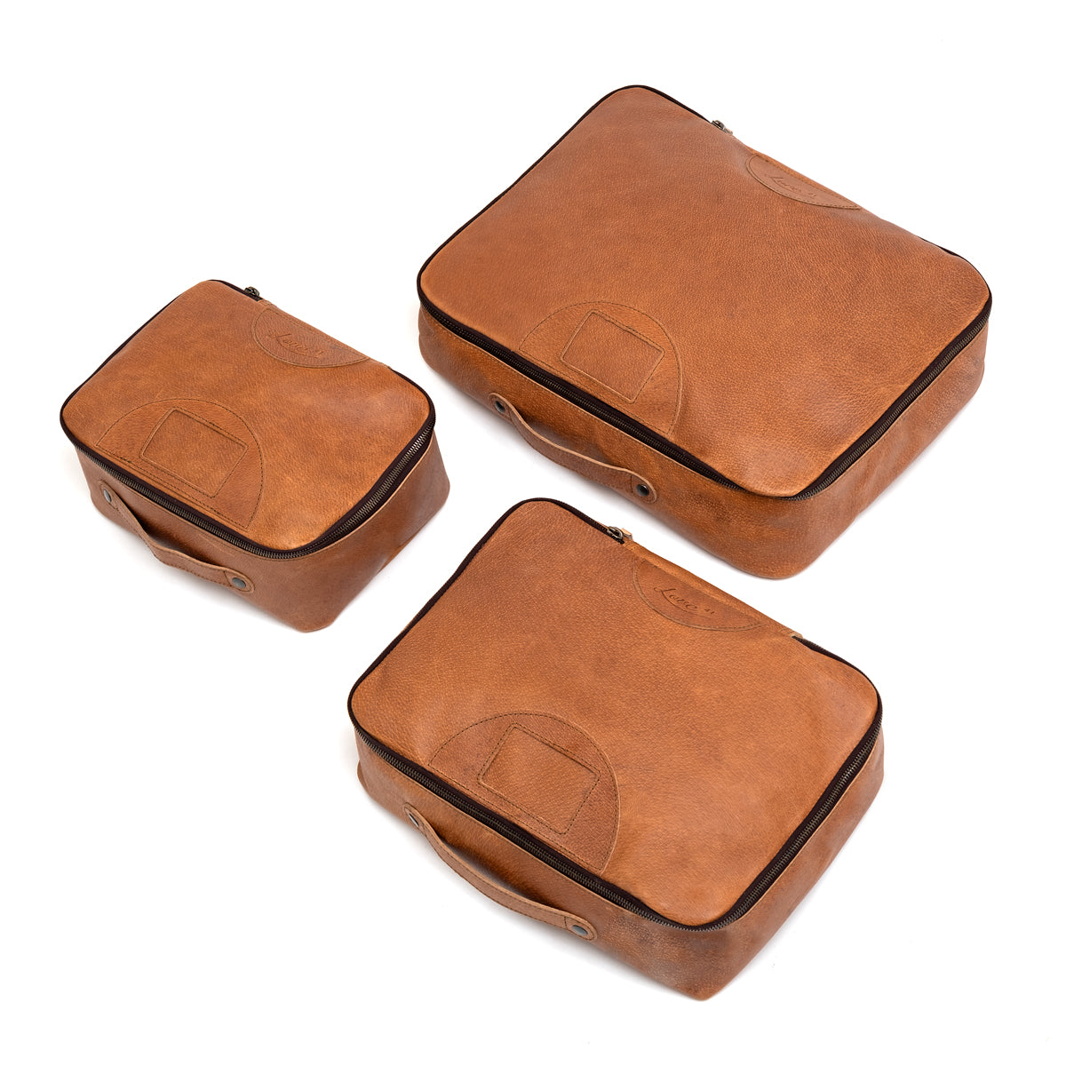 Pigskin Leather Packing Cube Set, small, medium and large cubes laid out side by side from above
