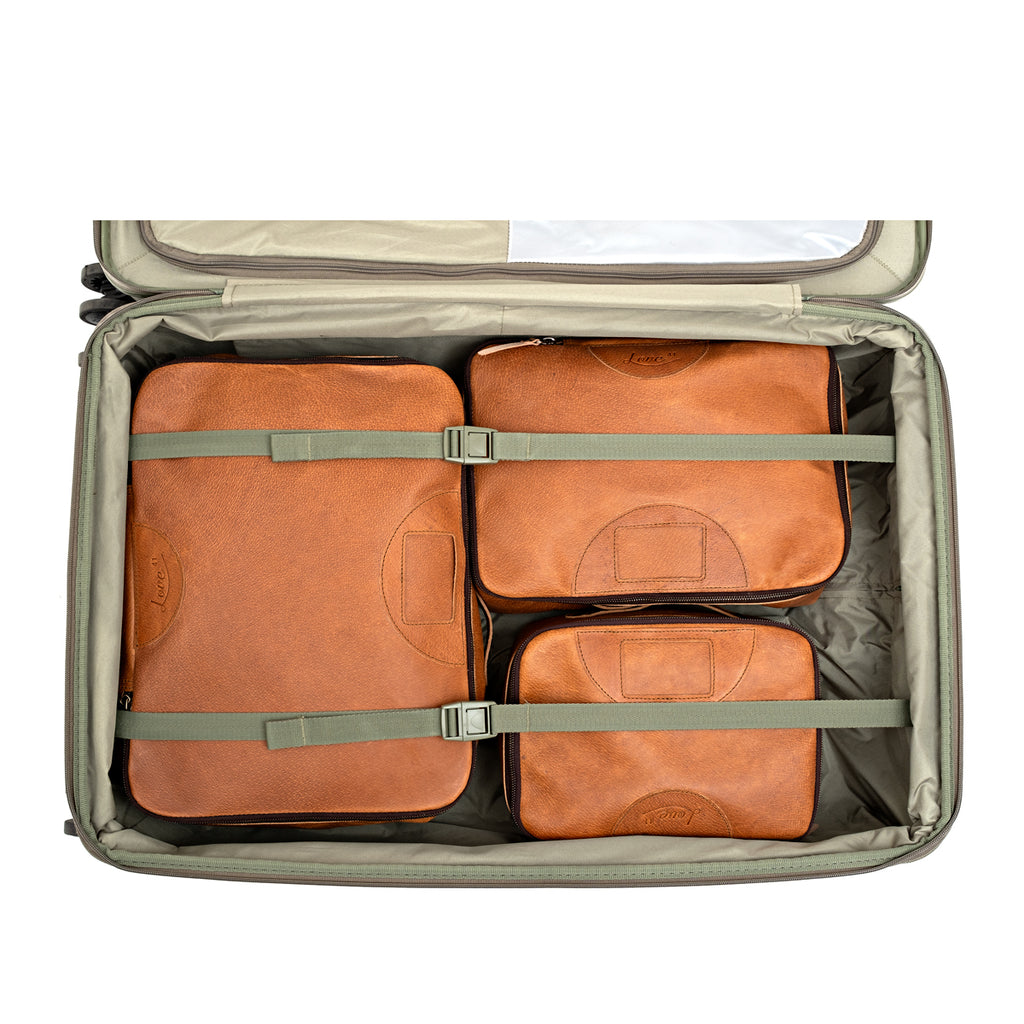 Pigskin Leather Packing Cube Set, three cubes packed and strapped inside an open rolling suitcase