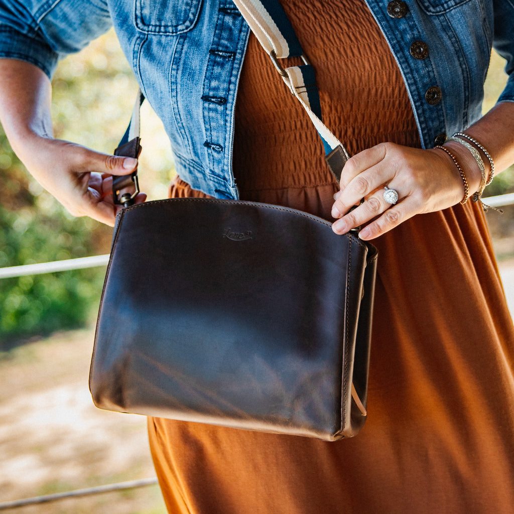 Leather Organizer Crossbody in a dark finish, worn over a rust dress and denim jacket with a light canvas strap