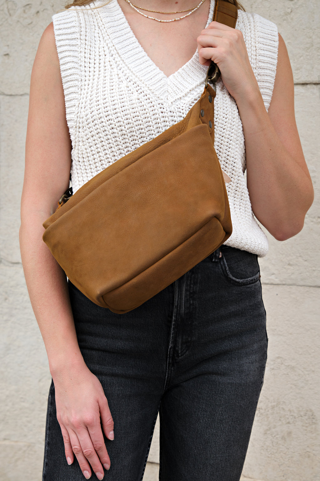 London Sling Small in Tobacco, worn across the chest over a white knit sweater vest