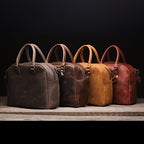 Professional Leather Satchel in Black, Dark Coffee Brown, Tobacco and Chestnut lined up in a row on a wood shelf