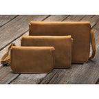 Magnetic Fold Over Bag Large in Tobacco, shown with two smaller fold over bags in three sizes on weathered wood