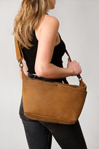 London Sling Large in Tobacco, carried on the shoulder by a woman in a black tank top
