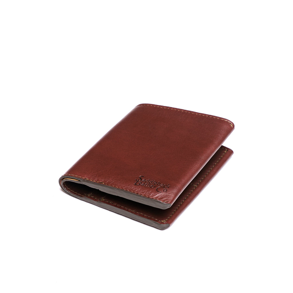 Large Bifold Wallet in Chestnut, closed and angled showing the stitched spine and embossed logo
