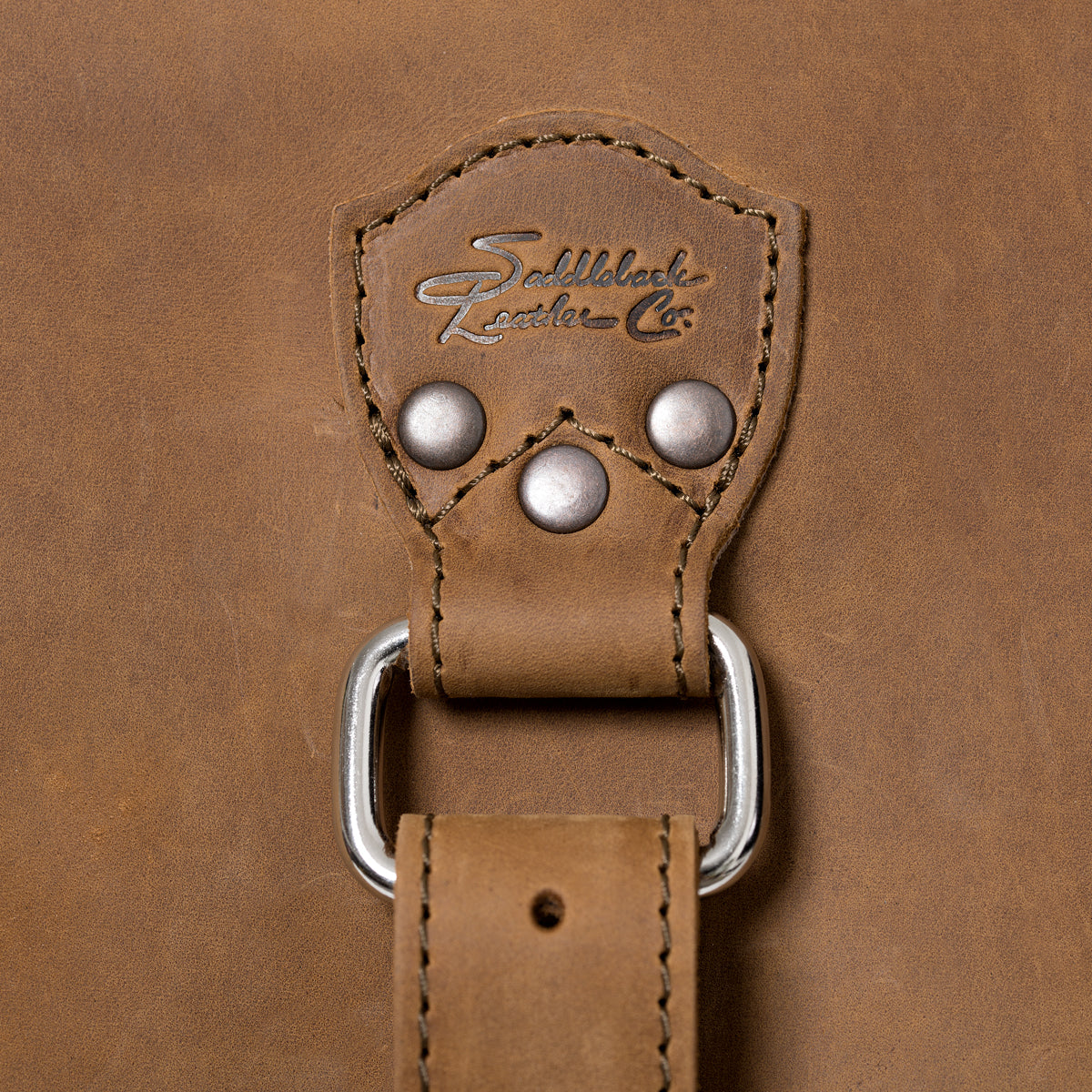 27" Adolescent Beast Duffle Bag in Tobacco, close-up of the embossed logo tab, rivets and D-ring strap