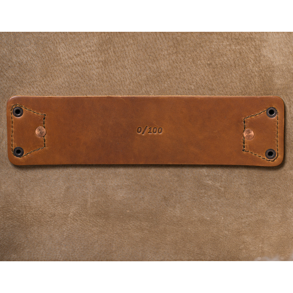27" Adolescent Beast Duffle Bag in Tobacco, close-up of the stamped leather tab riveted to the suede lining