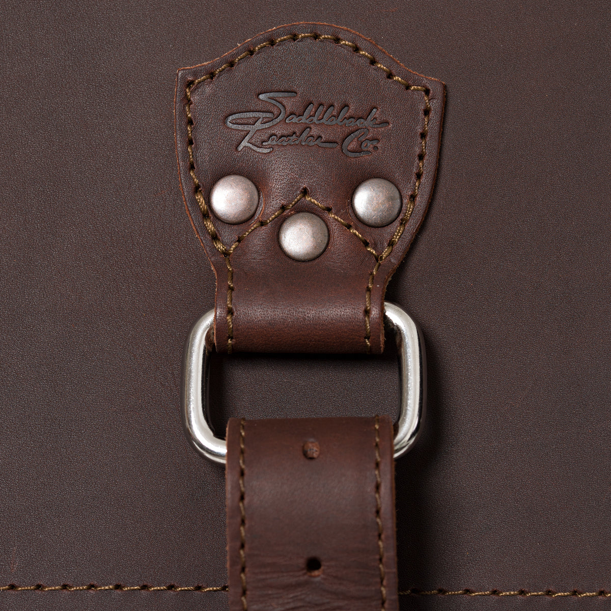 27" Adolescent Beast Duffle Bag in Chestnut, close-up of the embossed logo tab, rivets and D-ring strap