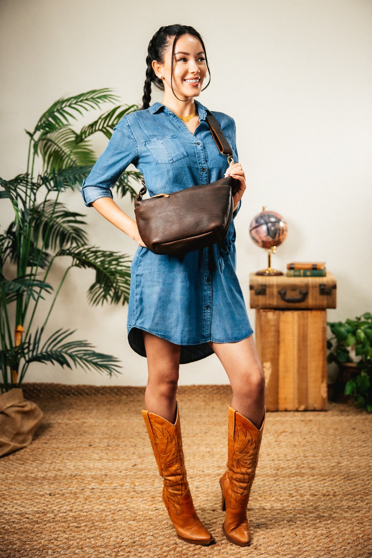 London Sling Small in Dark Coffee Brown, worn crossbody by a woman in a denim dress and cowboy boots
