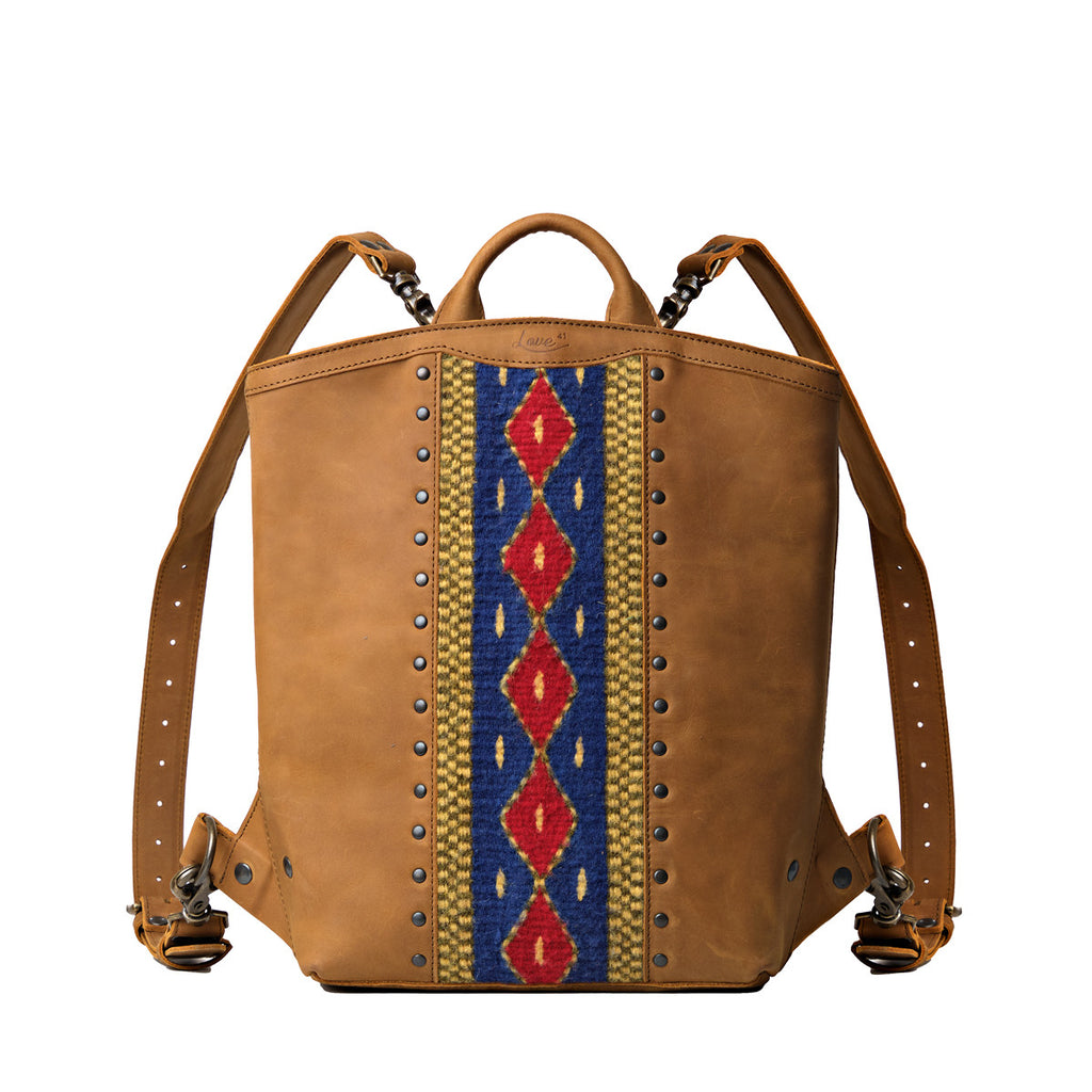 Lanita Leather Backpack in Tobacco, front view with blue and red woven panel, studs and top handle