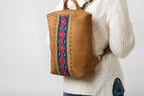 Lanita Leather Backpack in Tobacco, worn on the back by a model in a cream cable-knit sweater
