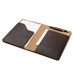 Medium Moleskin Cover in Dark Coffee Brown, open showing interior pockets with paper and a pen