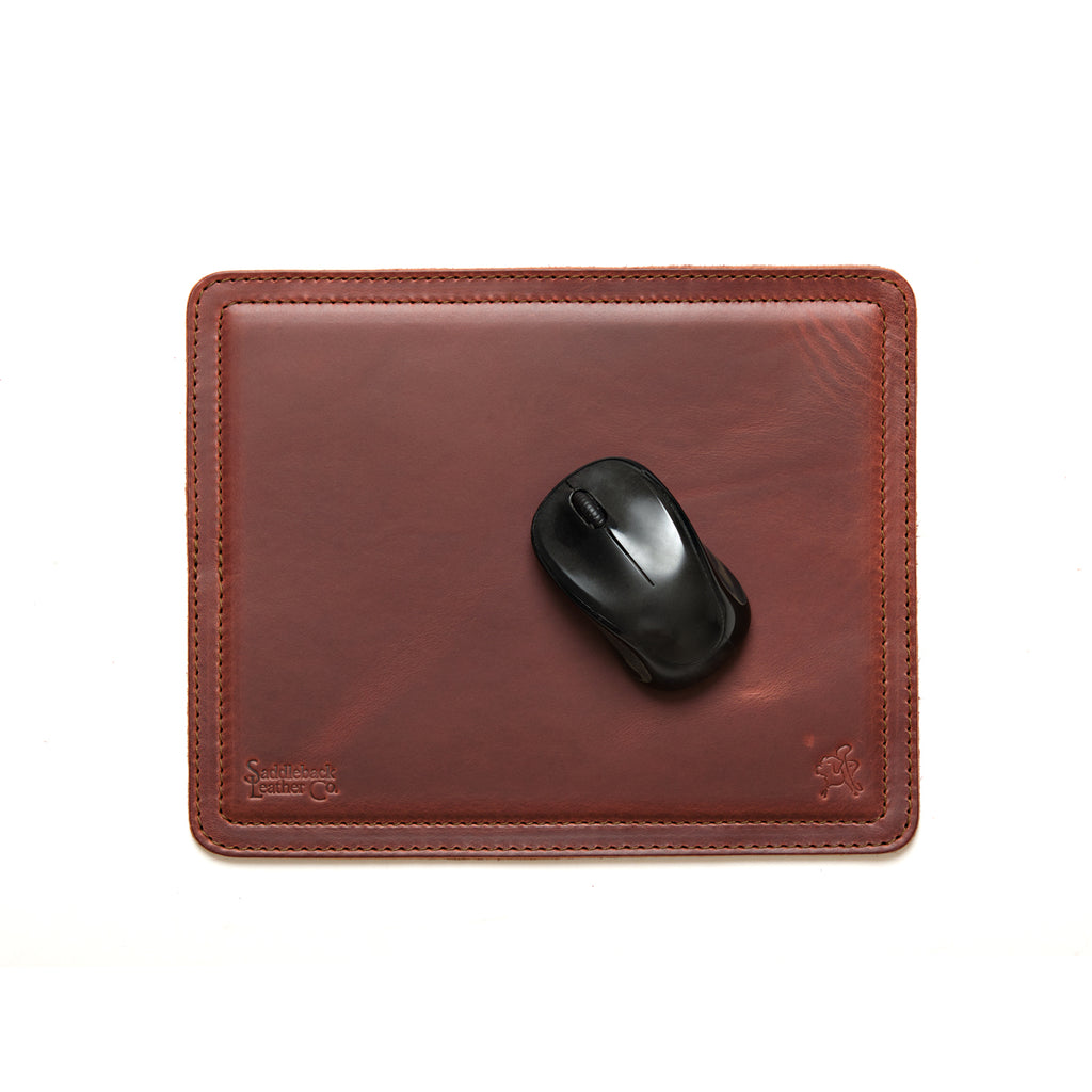 Mouse Pad in Chestnut leather with a black wireless mouse, overhead view showing stitched edges