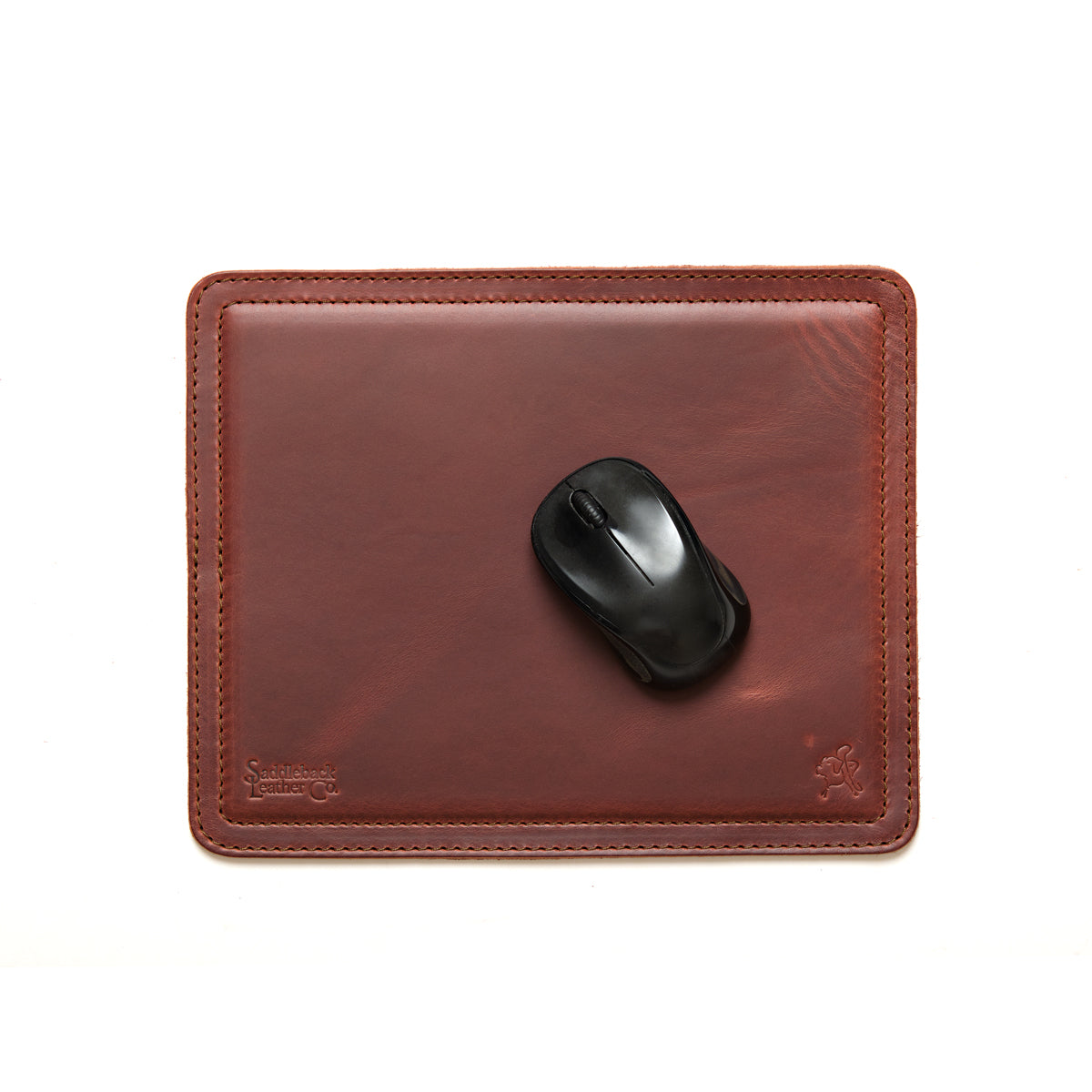 Mouse Pad in Chestnut leather with a black wireless mouse, overhead view showing stitched edges