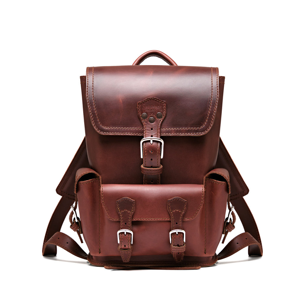 Small Front Pocket Backpack in Chestnut, front view showing the buckled flap, front pocket and shoulder straps