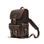 Small Front Pocket Backpack in Dark Coffee Brown, angled side view with the buckled front and side pockets and a shoulder strap