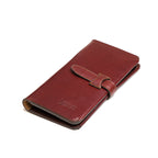 Big Wallet in Oxblood, closed angled view with strap closure and debossed logo
