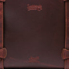 Original Tote in Chestnut, close-up of the leather panel with embossed logos and stitched strap loops
