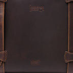 Original Tote in Dark Coffee Brown, close-up of the leather panel with embossed logos and stitched strap loops