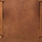 Original Tote in Tobacco, close-up of the leather panel with embossed logos and stitched strap loops