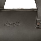 Simple Overnight Leather Duffle Bag in Black, close-up of the embossed Love 41 logo and riveted handle