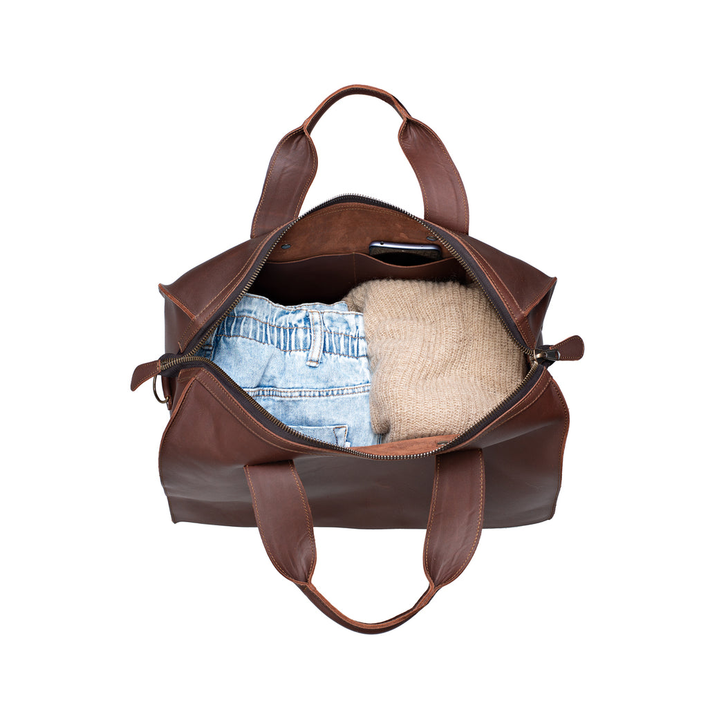 Simple Overnight Leather Duffle Bag in Chestnut, open top packed with folded jeans and a sweater