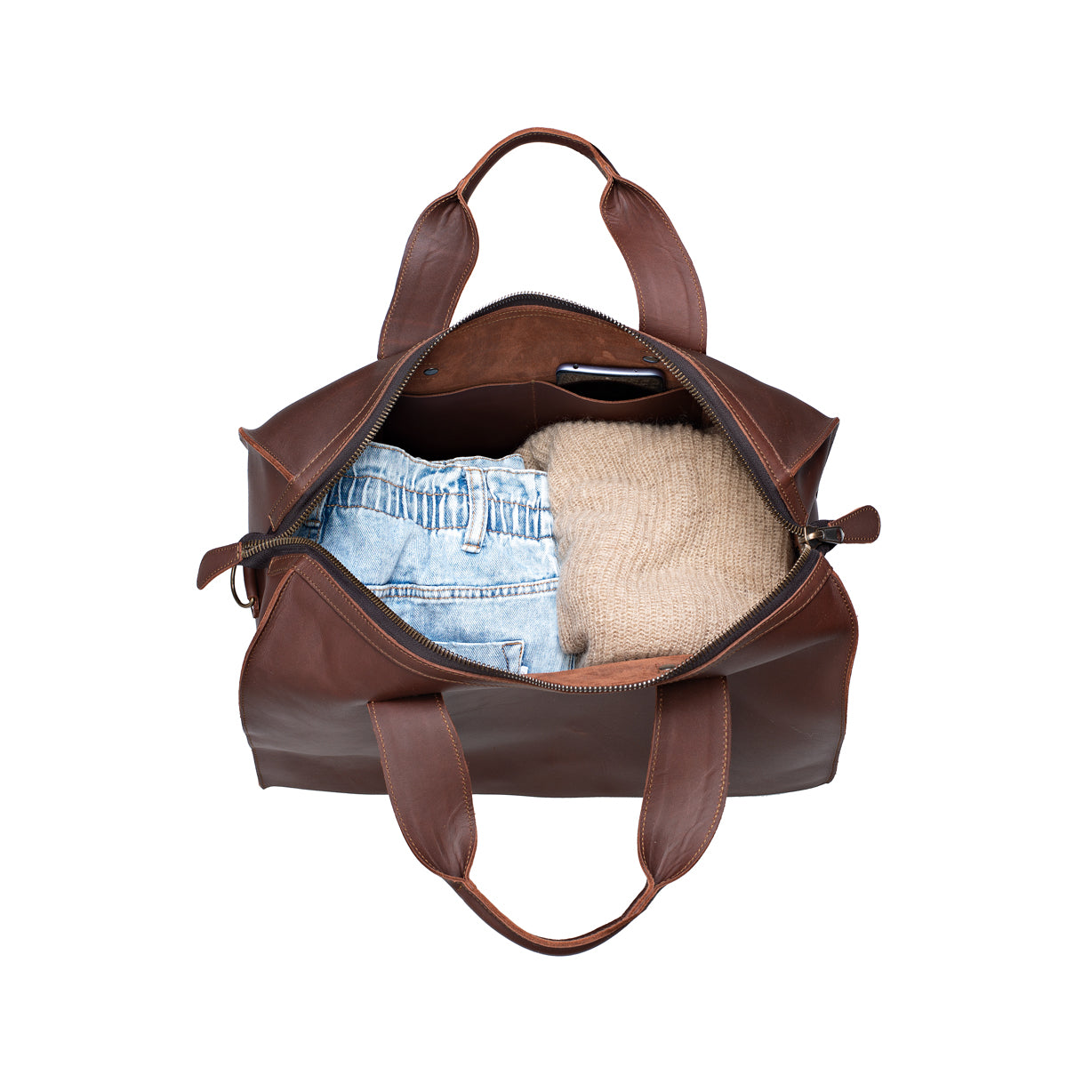 Simple Overnight Leather Duffle Bag in Chestnut, open top packed with folded jeans and a sweater