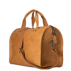 Simple Overnight Leather Duffle Bag in Tobacco, angled side view with shoulder strap clipped on