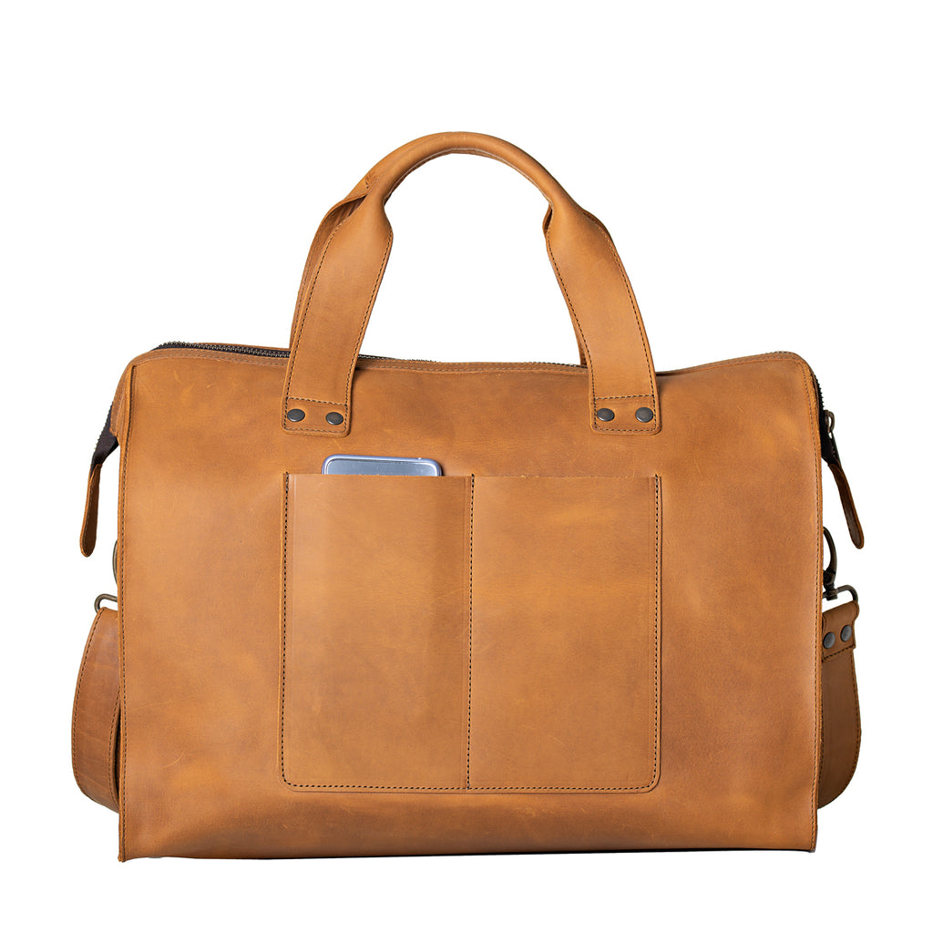 Simple Overnight Leather Duffle Bag in Tobacco, back view with exterior slip pockets holding a phone