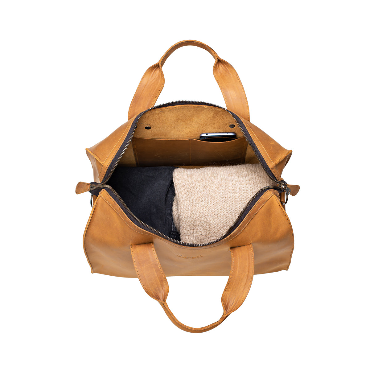Simple Overnight Leather Duffle Bag in Tobacco, open top packed with dark jeans and a sweater