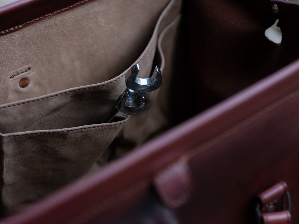 Leather Range and Tool Bag in Chestnut, close-up of an interior slip pocket holding a wrench