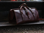 Leather Range and Tool Bag in Chestnut, angled view on a weathered truck tailgate above gravel
