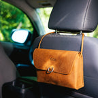 Large Leather Organizer Bag in Tobacco hanging from a car seat headrest by its leather tie