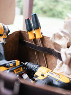 Close-up inside the Range and Tool Tote showing an interior strap holding screwdrivers beside cordless drills