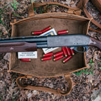 Range and Tool Tote in Tobacco open on fallen leaves, holding a shotgun, shotgun shells and ammo boxes