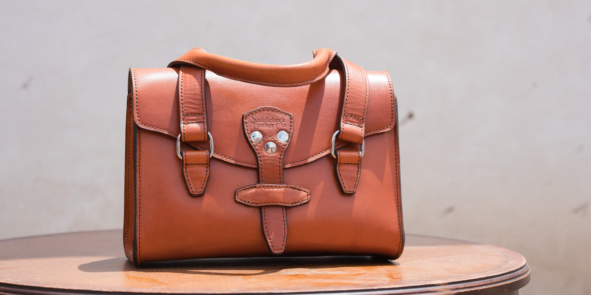 Double Handle Purse in English Tan on a round wooden table against a light gray wall