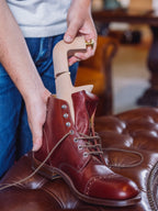 Shoe Tree being slid into an unlaced reddish brown leather boot