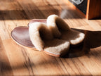 Men's Sheepskin Slippers in Dark Coffee Brown with thick sheepskin lining, in sunlight on a wood floor
