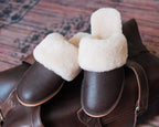 Women's Sheepskin Slippers in Dark Coffee Brown, front view of pair resting on a leather bag