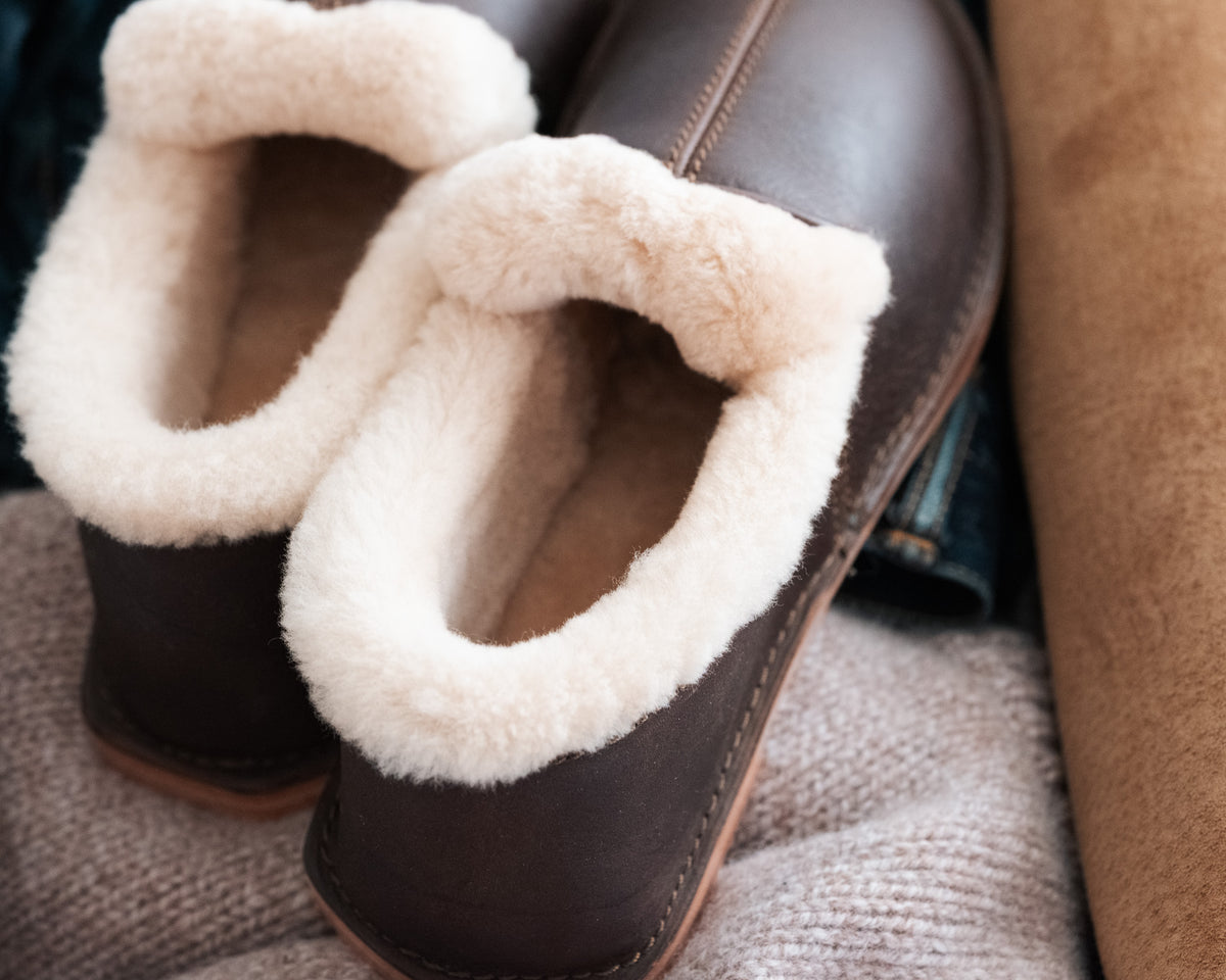 Sheepskin Moccasins in Dark Coffee Brown, close-up of the plush cream shearling heel cuffs from behind